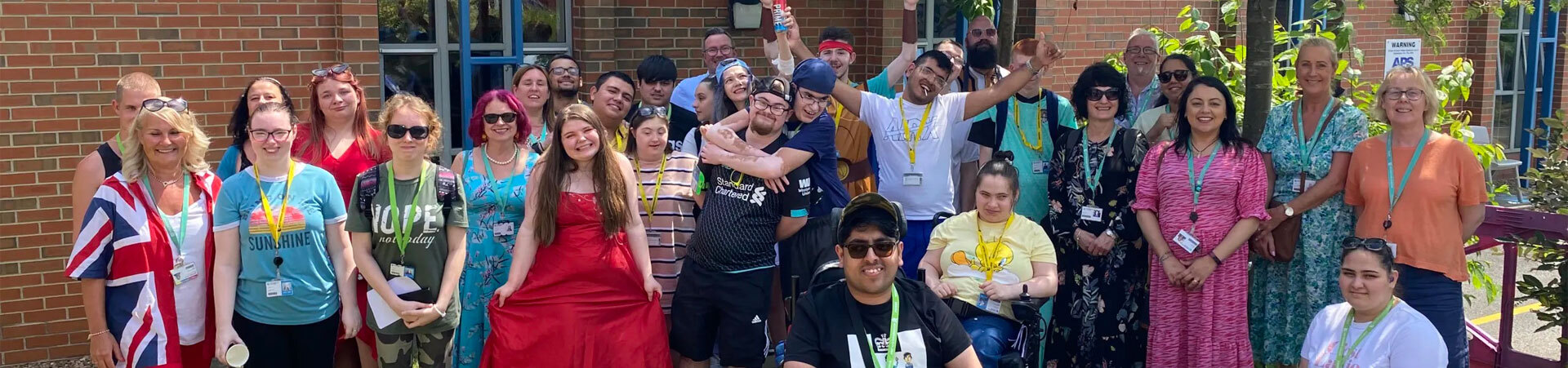 Supported Learning students with staff standing outside.