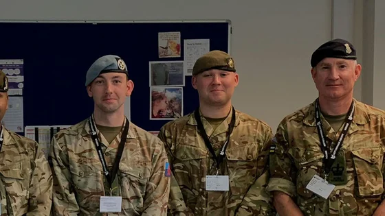 Public service students in army uniform with staff.
