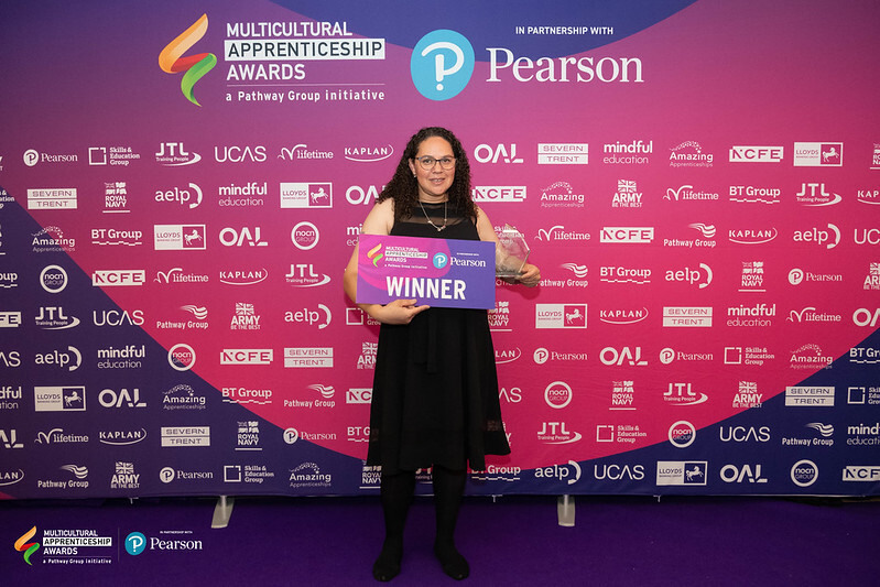 A person smiling holding an award