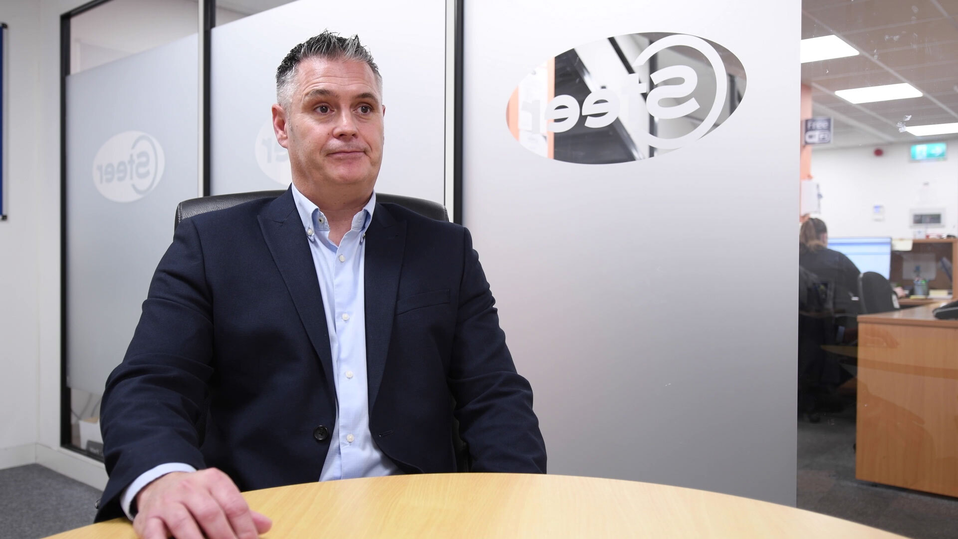 A man sat at a table smiling
