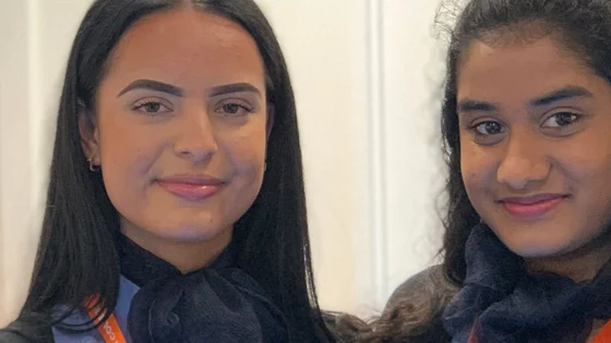Two students in travel and tourism uniform in the aircraft cabin at the City Hub