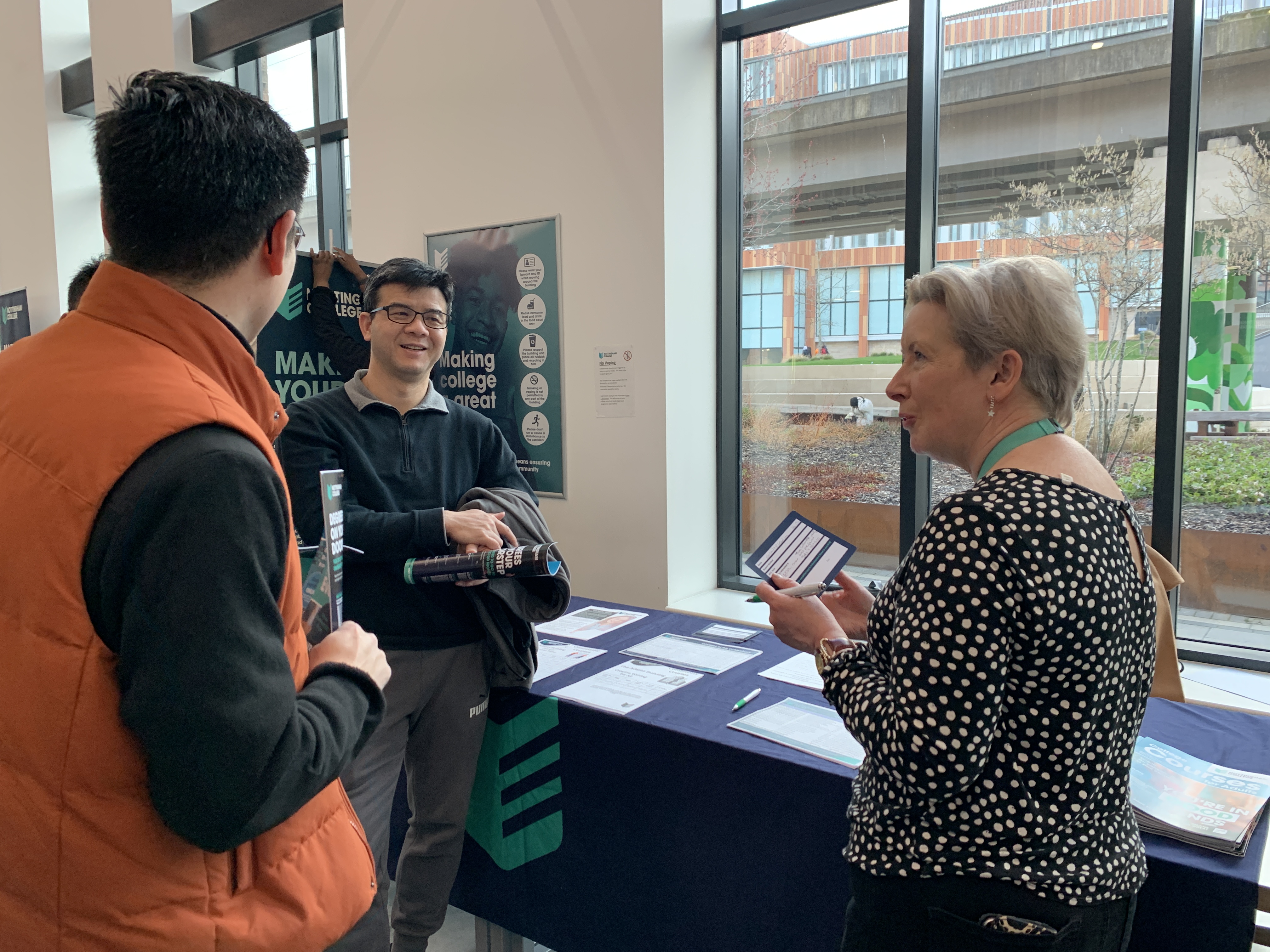 2 visitors with a member of staff at our Adult Information Open Event