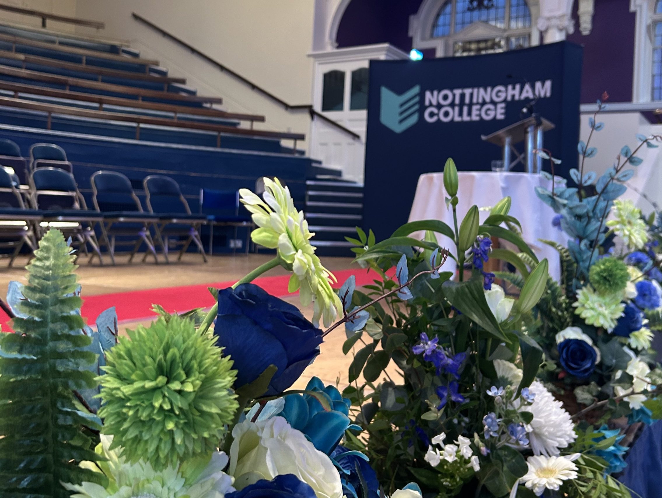 Flowers and Nottingham College banners on the stage