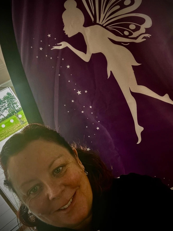 Emma Shipstone in front of a Gifts with fairies banner