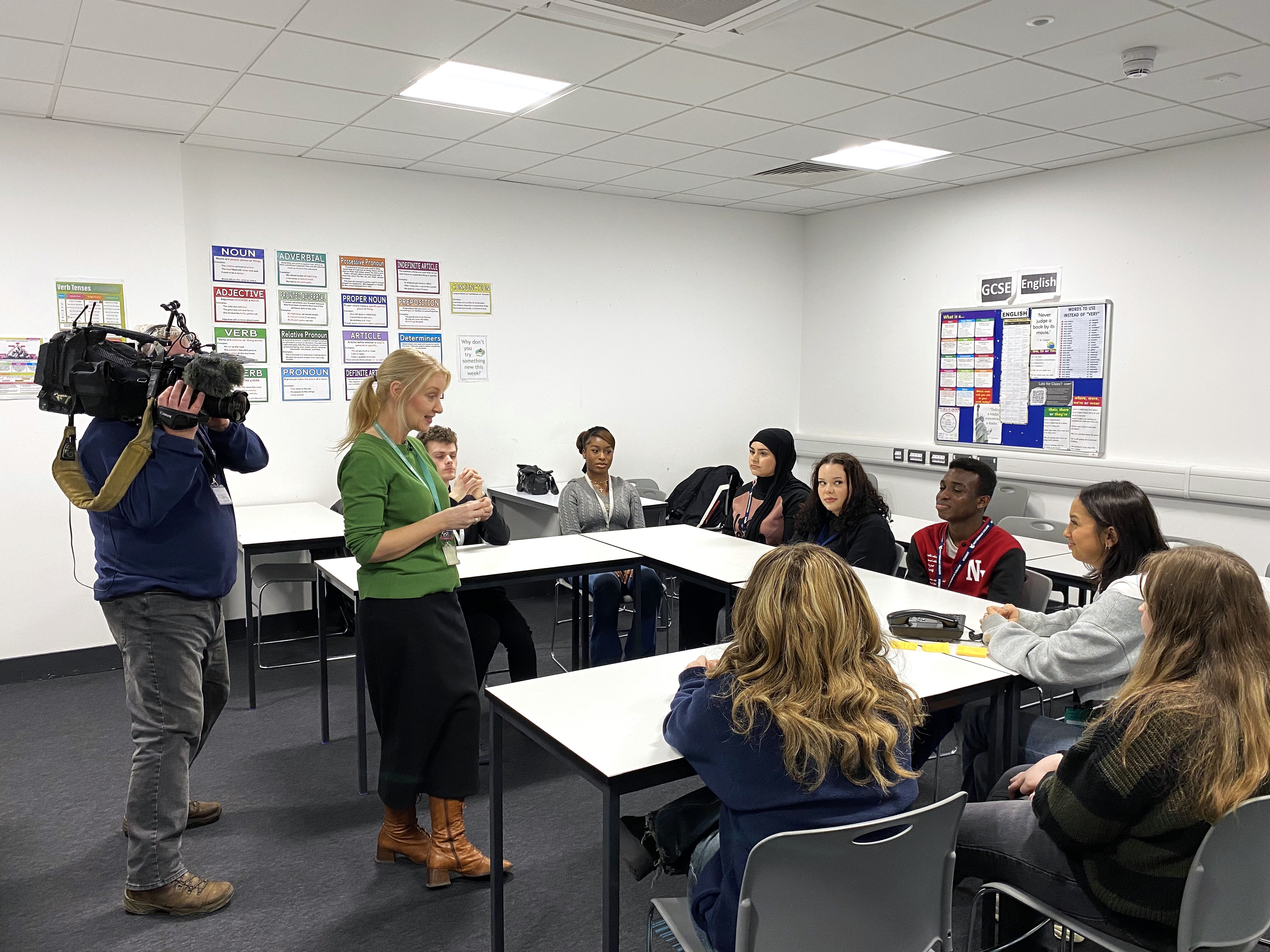 Students and staff in a classroom with a cameraman.