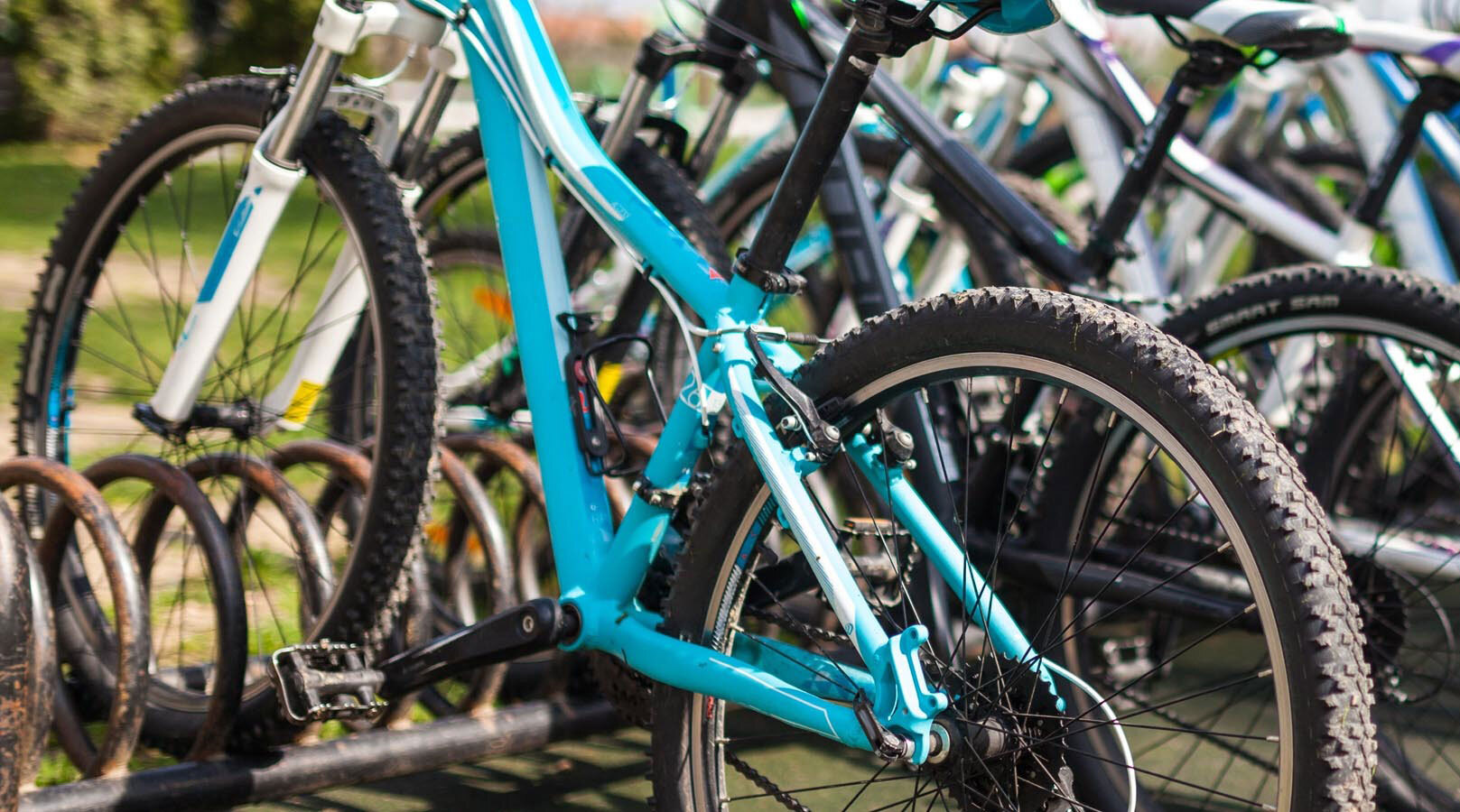 A row of bikes in a bike rack.