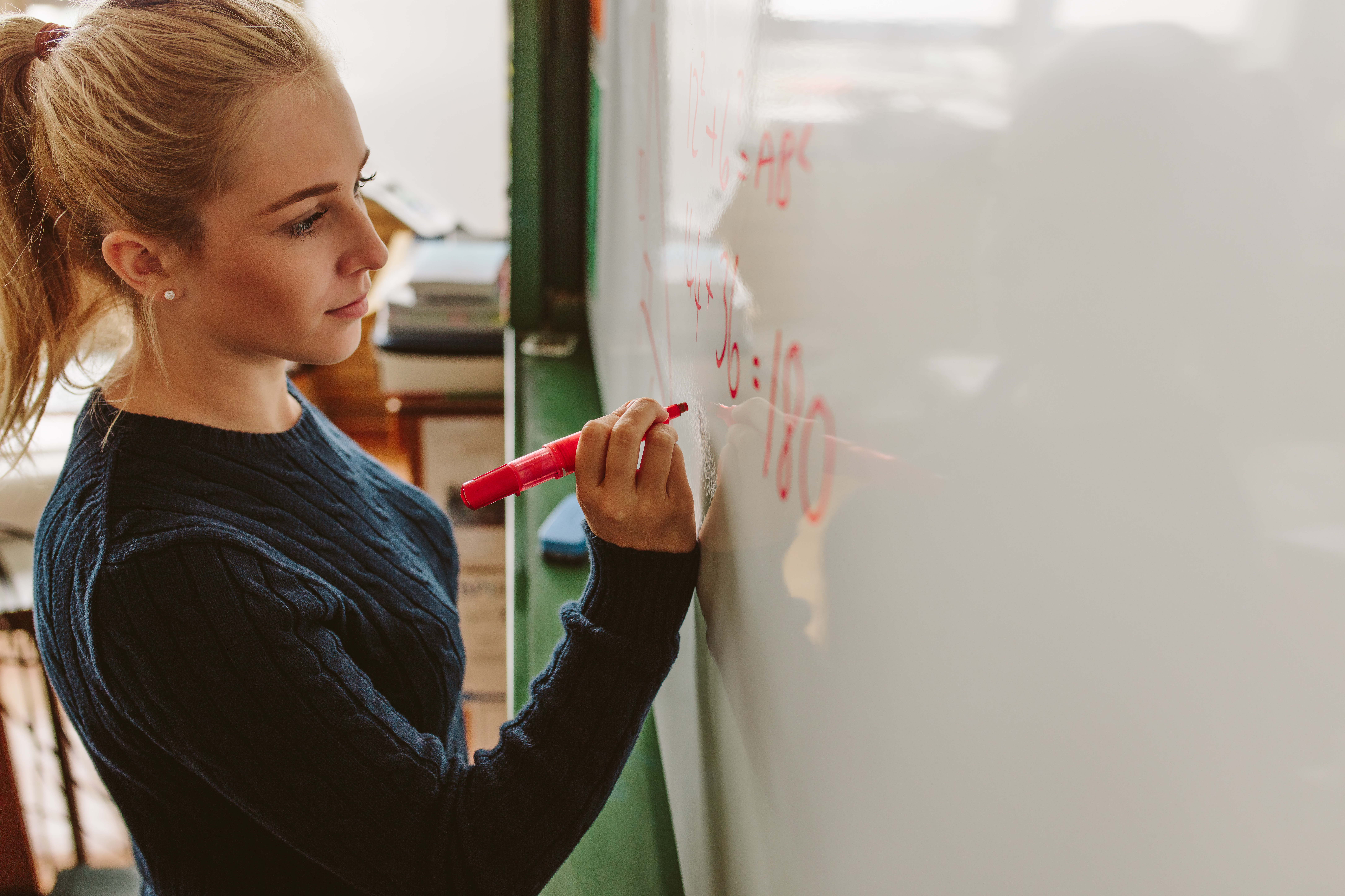 A lecturer writing on a whiteboard