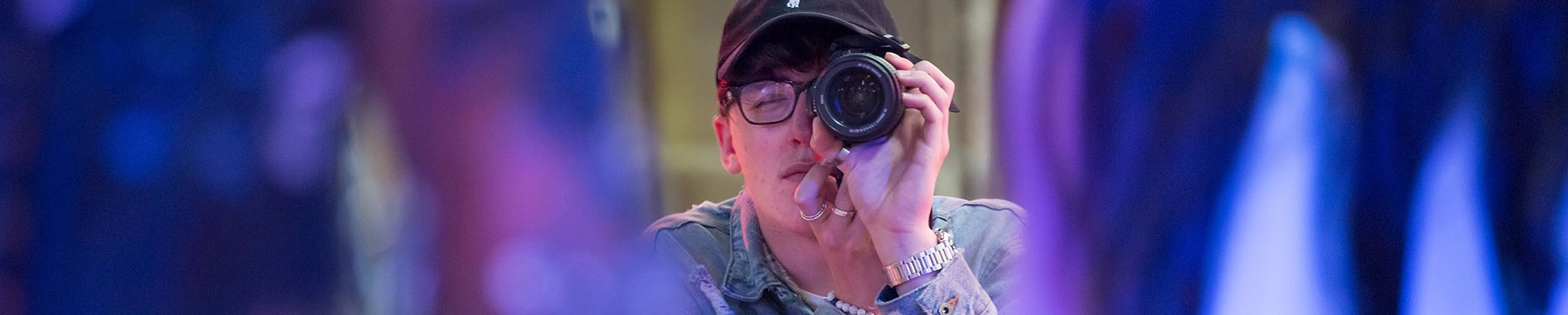 A student looking through the lens of a camera