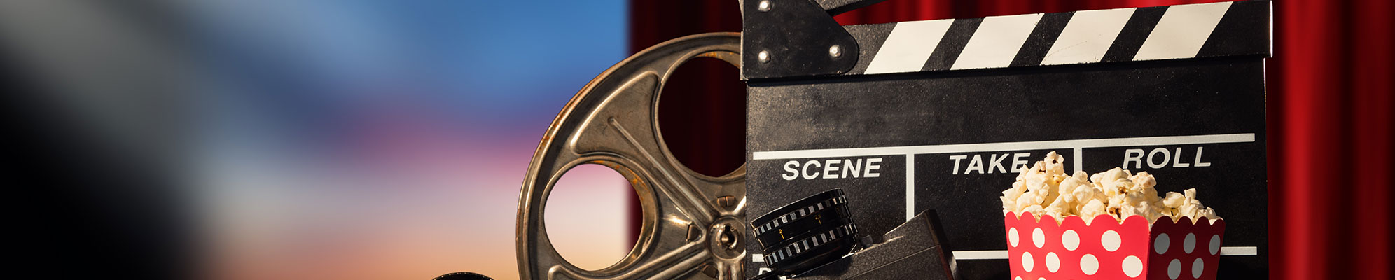 A picture of a film reel, a clapperboard and popcorn