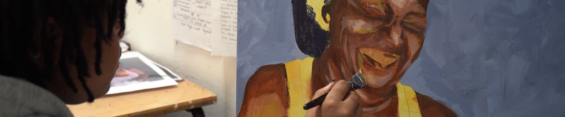 A student painting a picture of a smiling lady