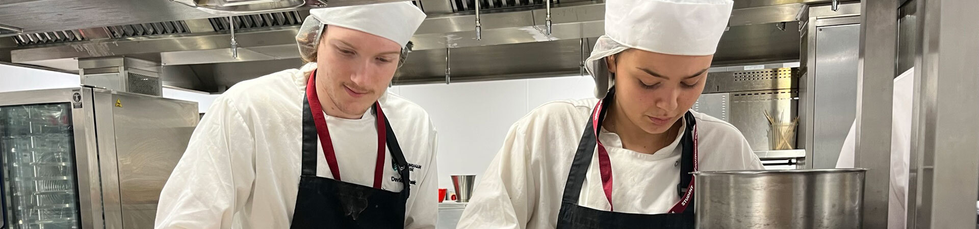 Two students working in our professional training kitchen at the City Hub