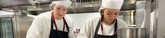Two students working in our professional training kitchen at the City Hub