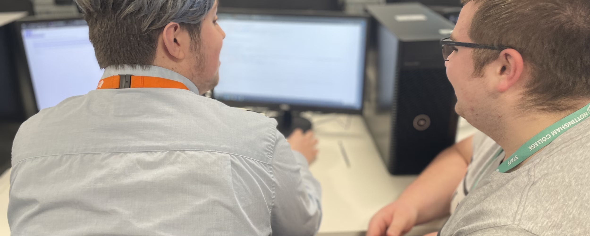A student and lecturer in front of a computer screen.