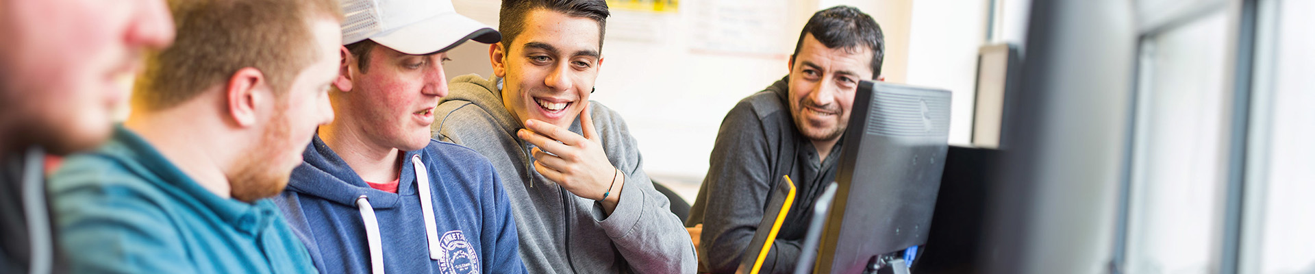 A group of HE students looking at a computer screen.
