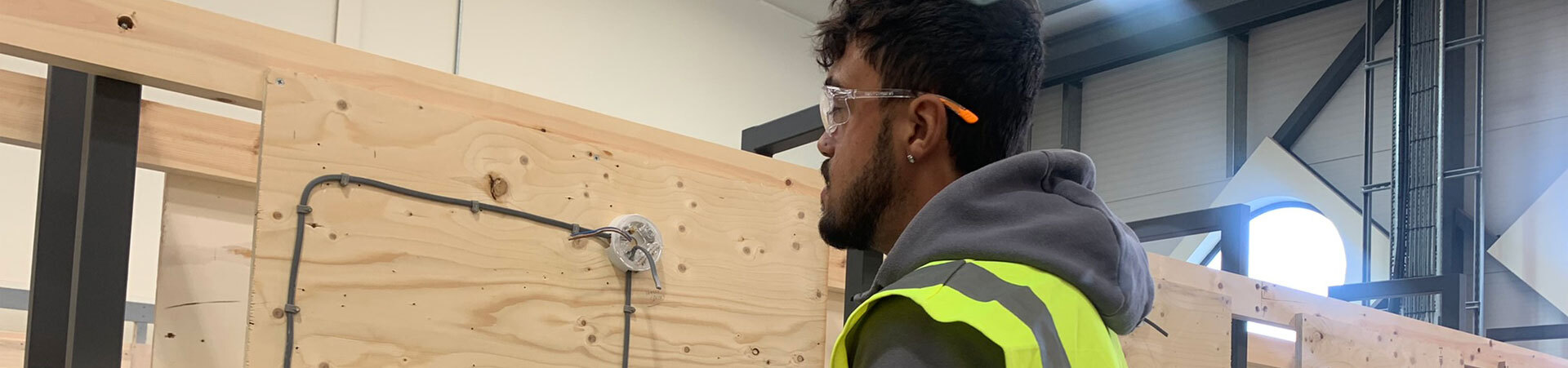 A student looking at a wiring look on a piece of wood.