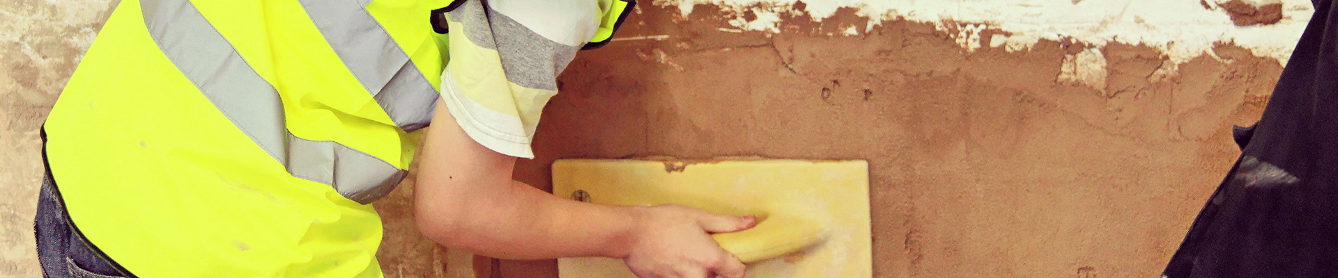 A student plastering a wall