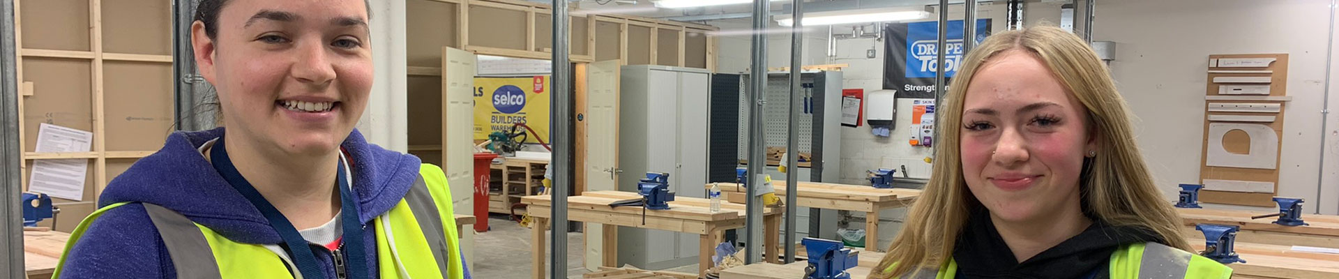 Two female students in a construction workshop