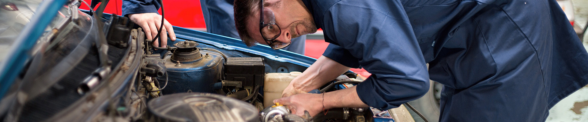A student working on a car engine.