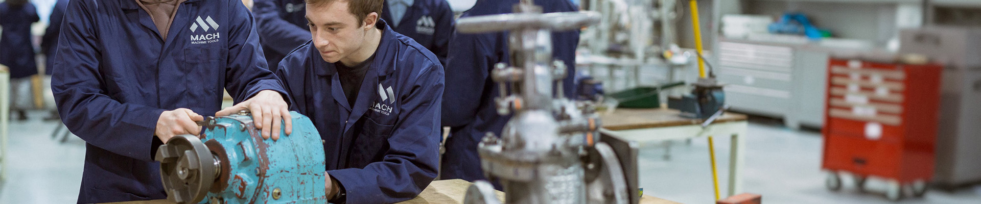 Students working on machinery in an engineering workshop.