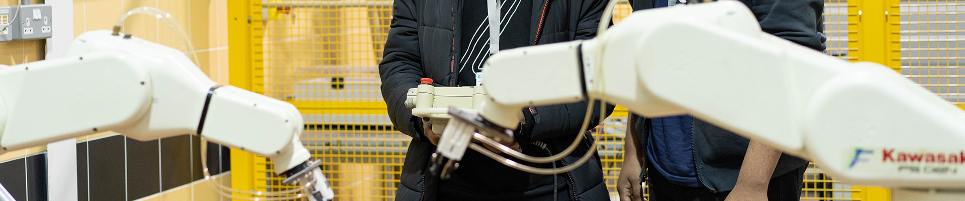 Two student controlling robots to do tasks.