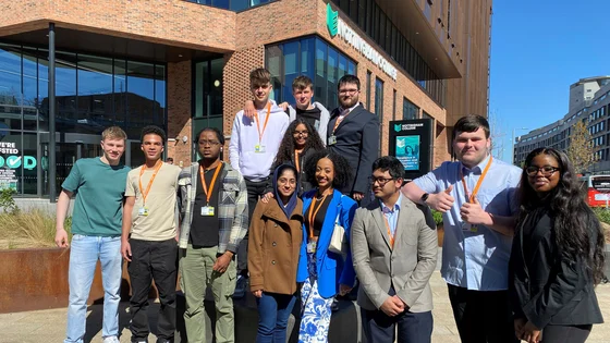A large group of students stood together outside of the City Hub campus