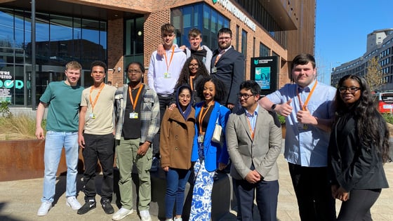 A large group of students stood together outside of the City Hub campus