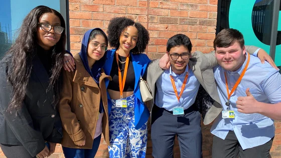Smiling students standing outside the City Hub.