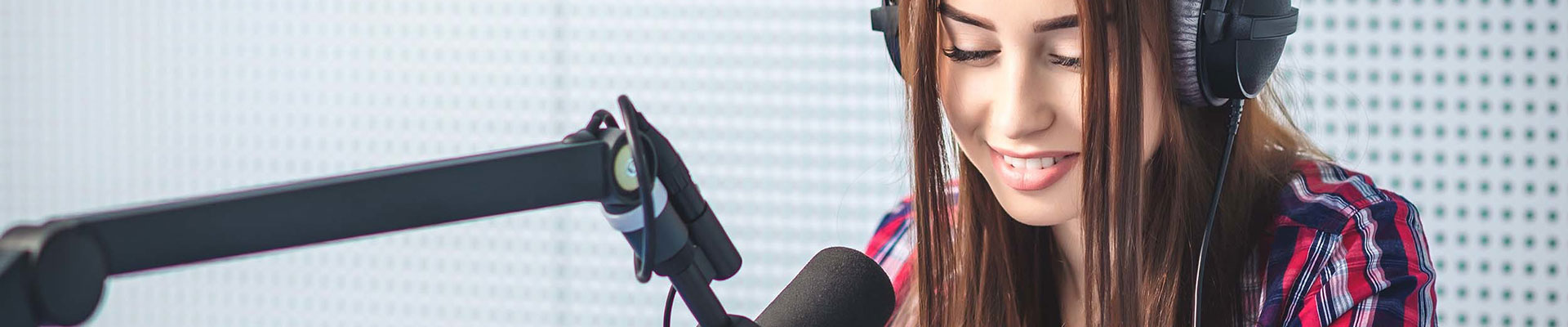 A student wearing headphones speaking into a microphone