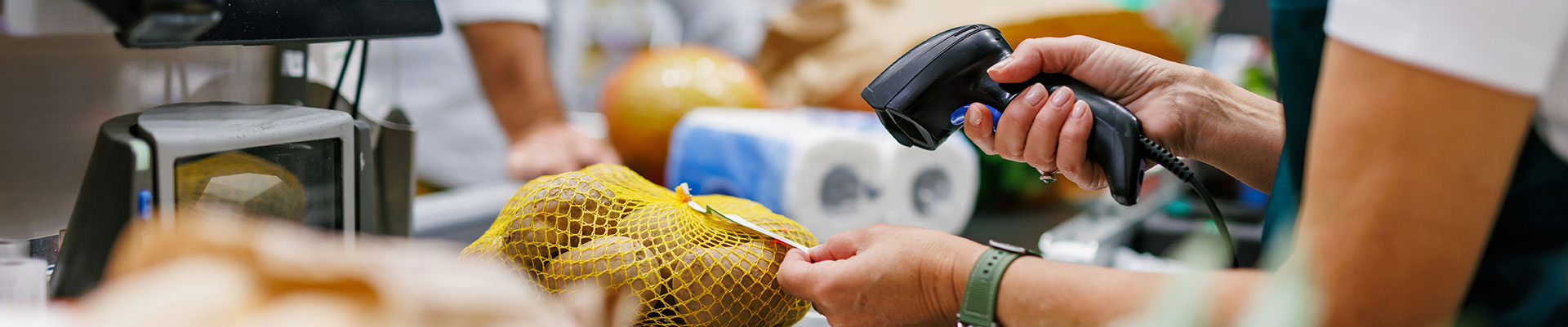 A person scanning groceries in a supermarket.