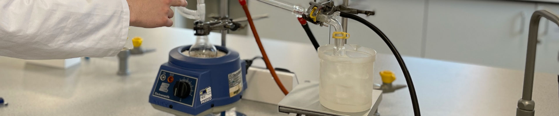 A student using science equipment to conduct an experiment in a science lab.