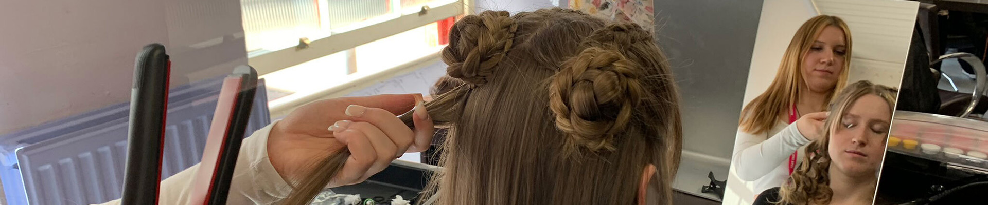 A student styling a client's hair.