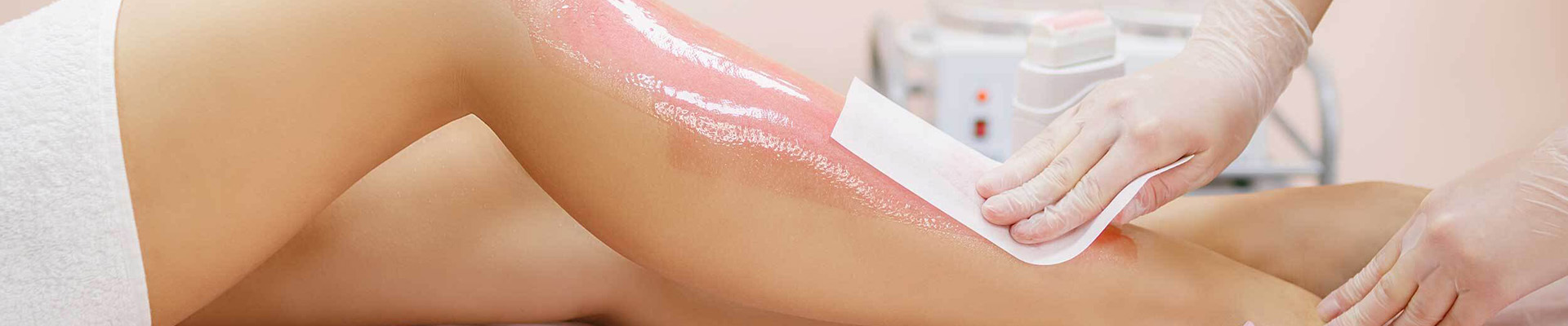 A therapist waxing a client's leg.