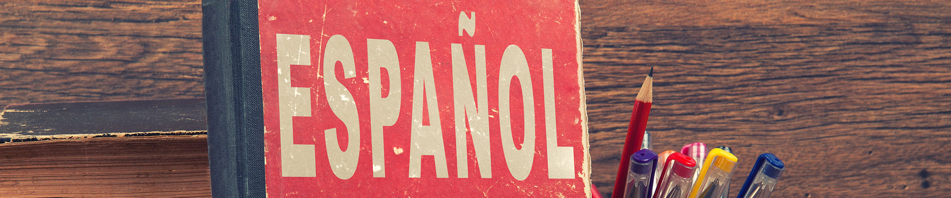 An old book entitled ESPANOL with pens and pencils