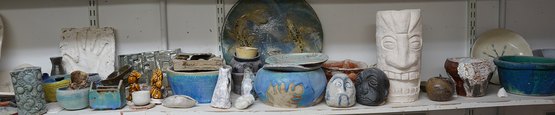 A selection of students' work on a shelf after firing.