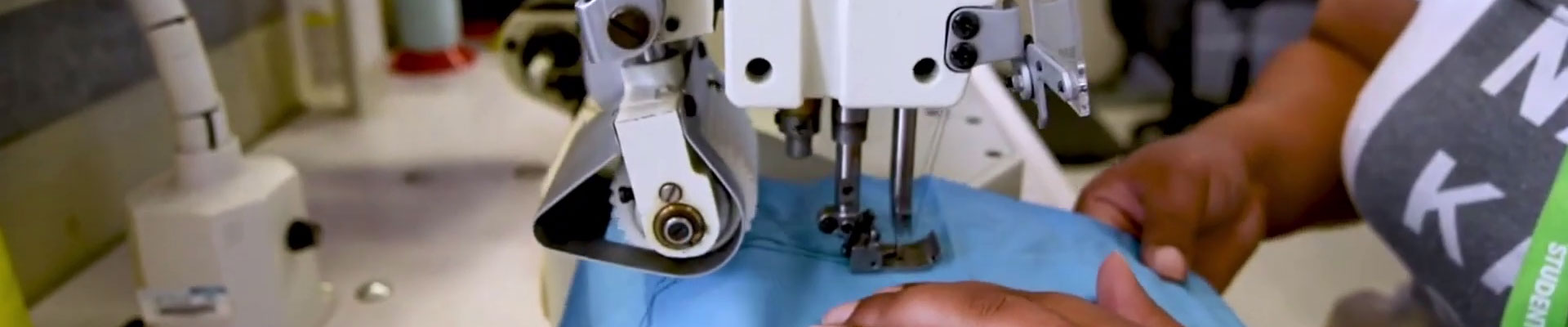 A student using an industrial sewing machine