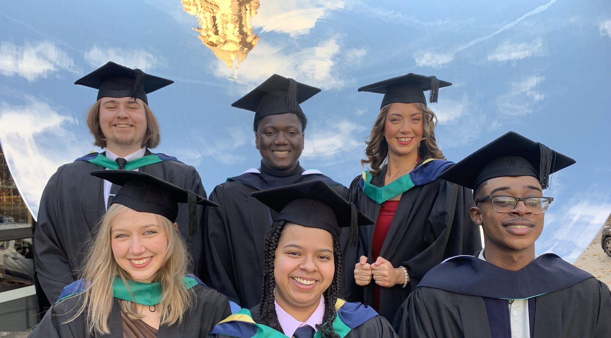 6 graduates in two rows on graduation day 2023