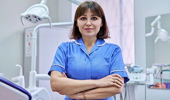 A dental nurse standing in a dentist's surgery.