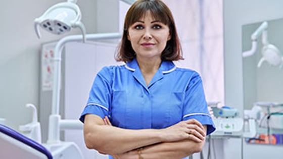 A dental nurse standing in a dentist's surgery.