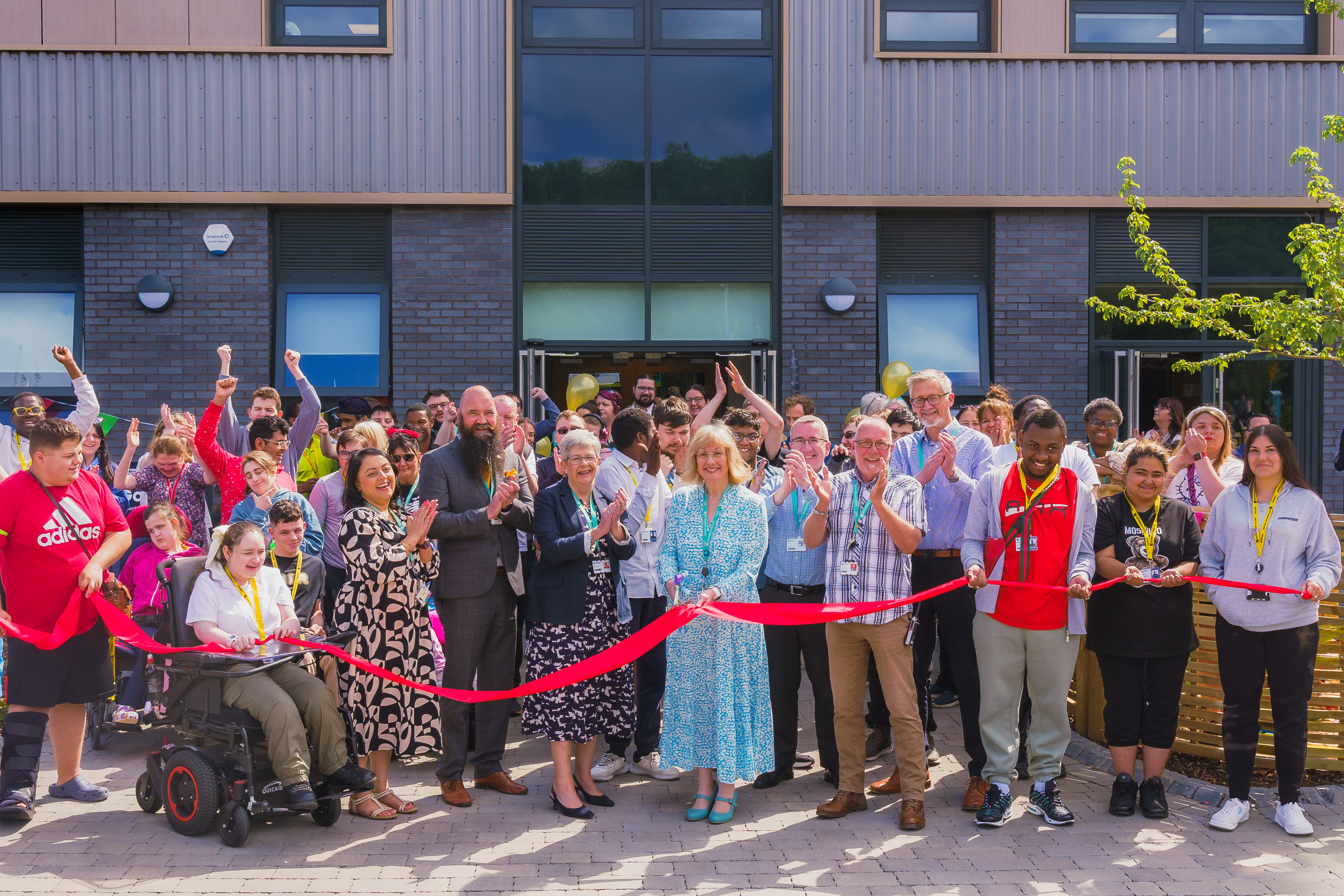 Students and staff cutting the ribbon outside the Gateway
