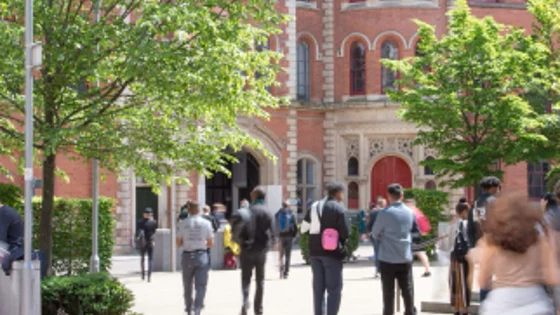 An external shot of the Adams Building courtyard with students walking around in the sun