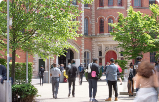An external shot of the Adams Building courtyard with students walking around in the sun