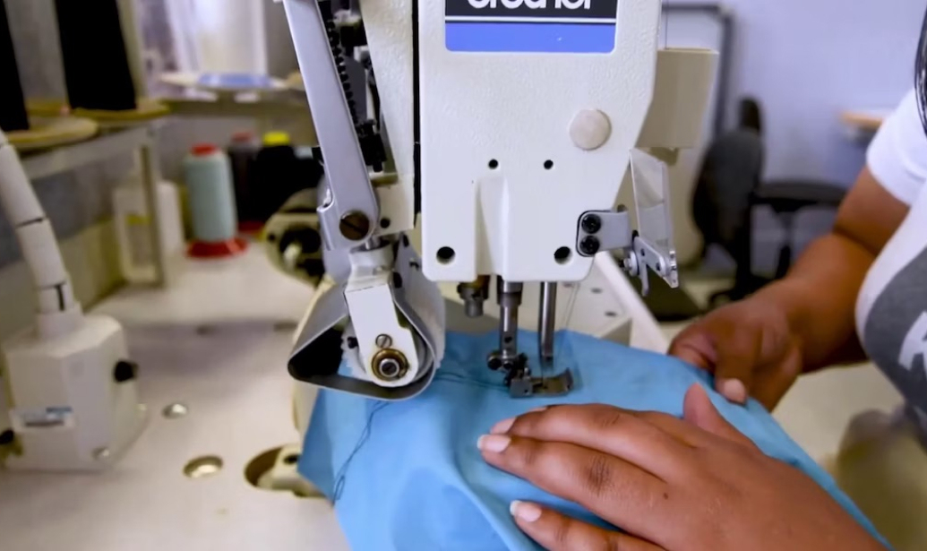 Student using a sewing machine to sew some fabric