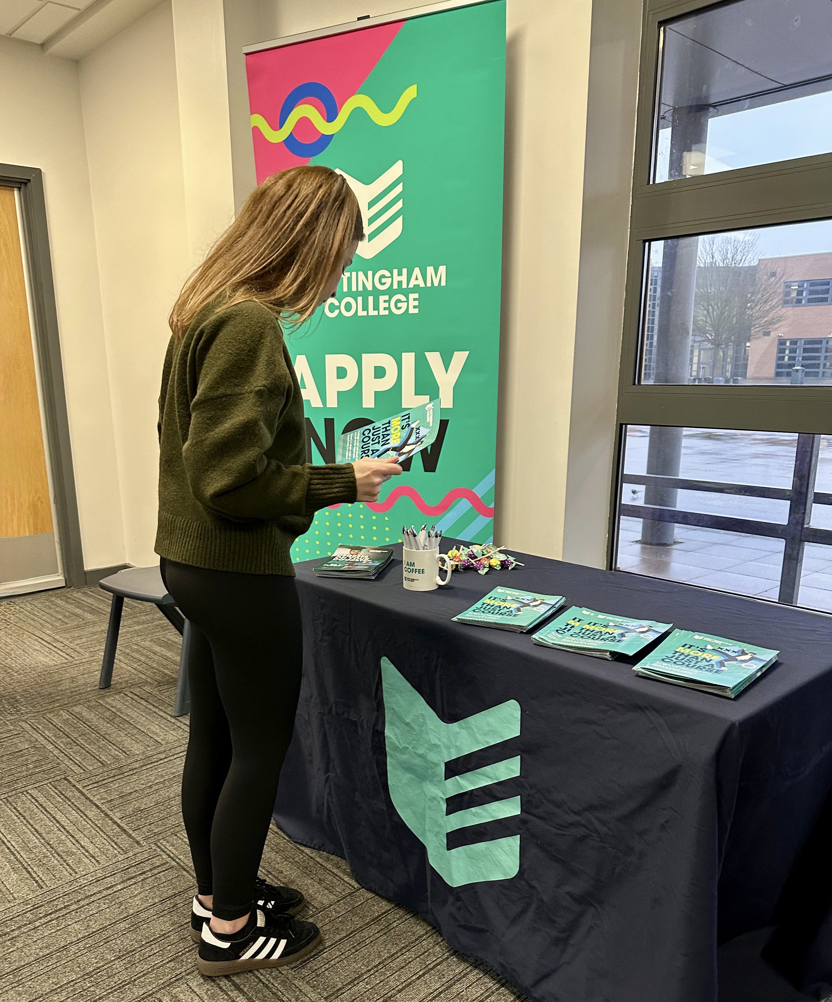 Person at a careers stand with information on a table.