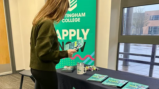 Person at a careers stand with information on a table.