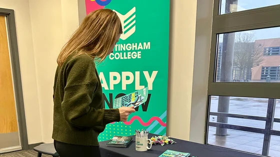 Person at a careers stand with information on a table.