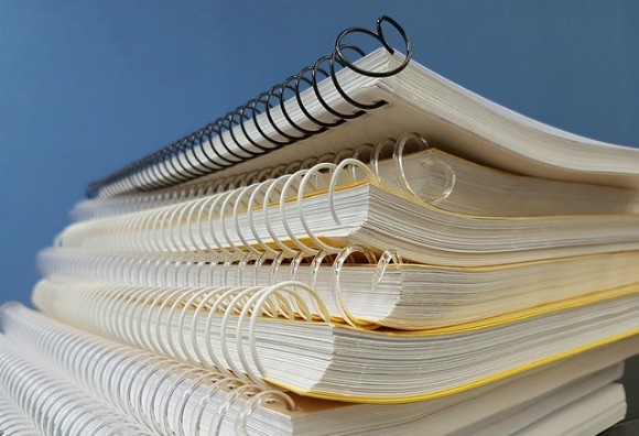 A pile of notebooks with binders