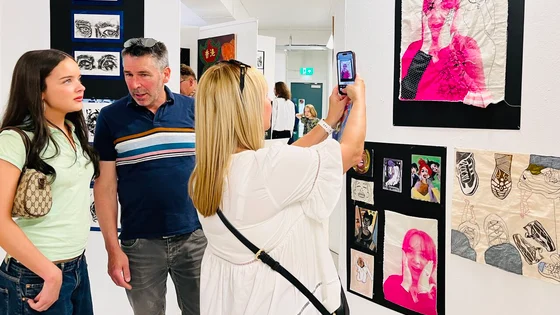 Visitors looking at student artwork on a wall