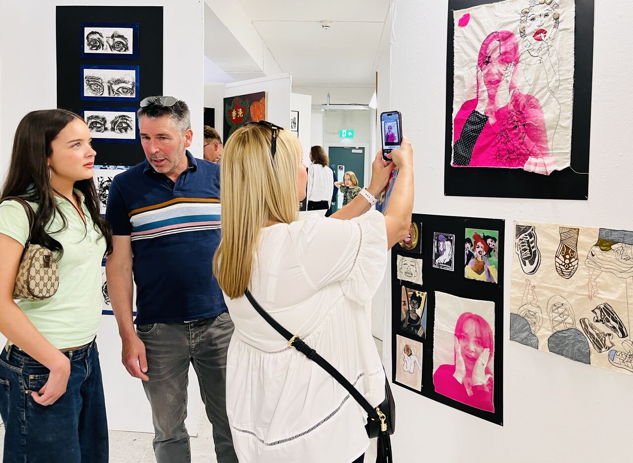 Visitors looking at student artwork on a wall