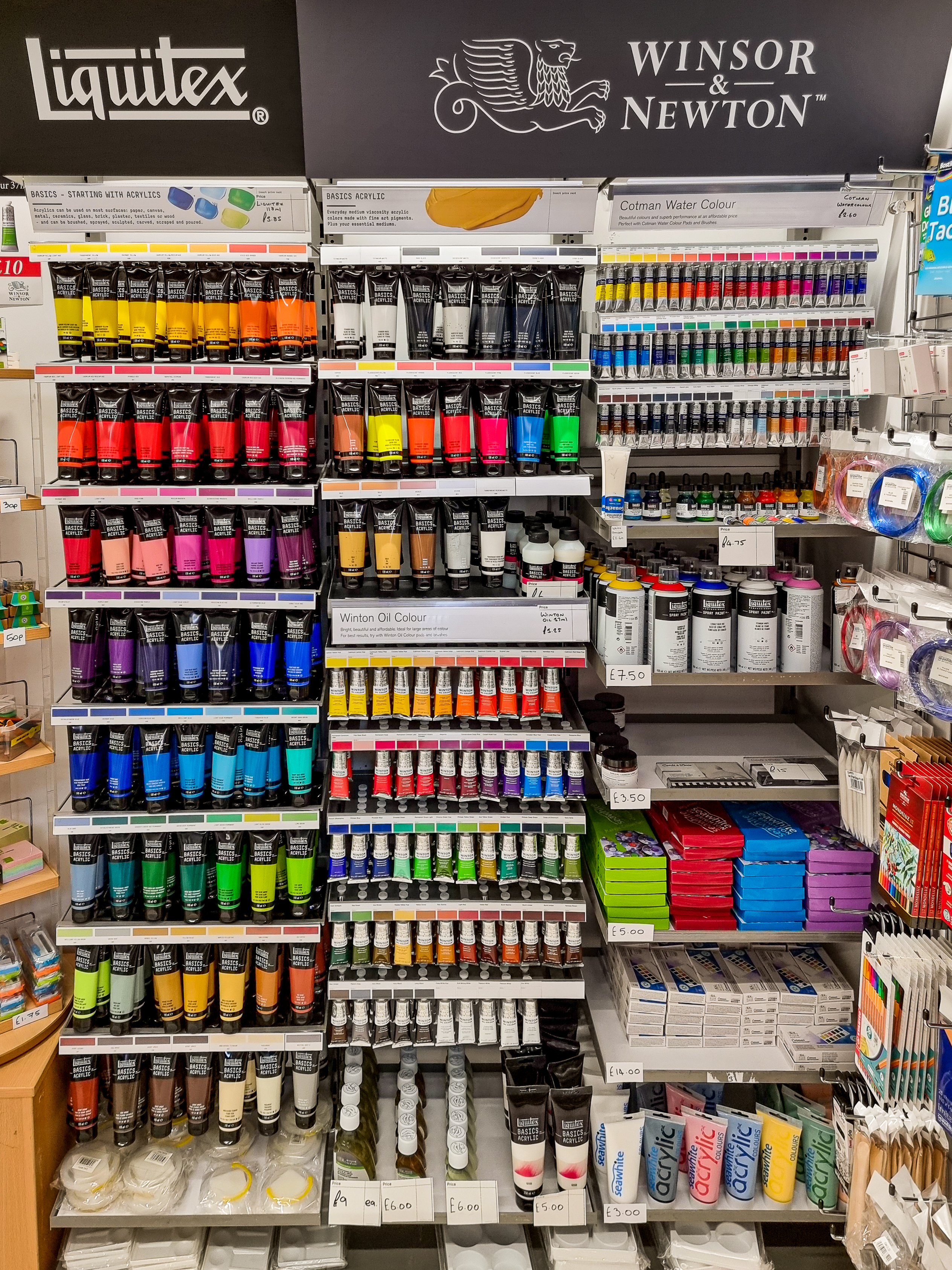 A shelf with different coloured paint tubes