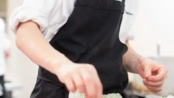 A catering student preparing some food in the kitchen